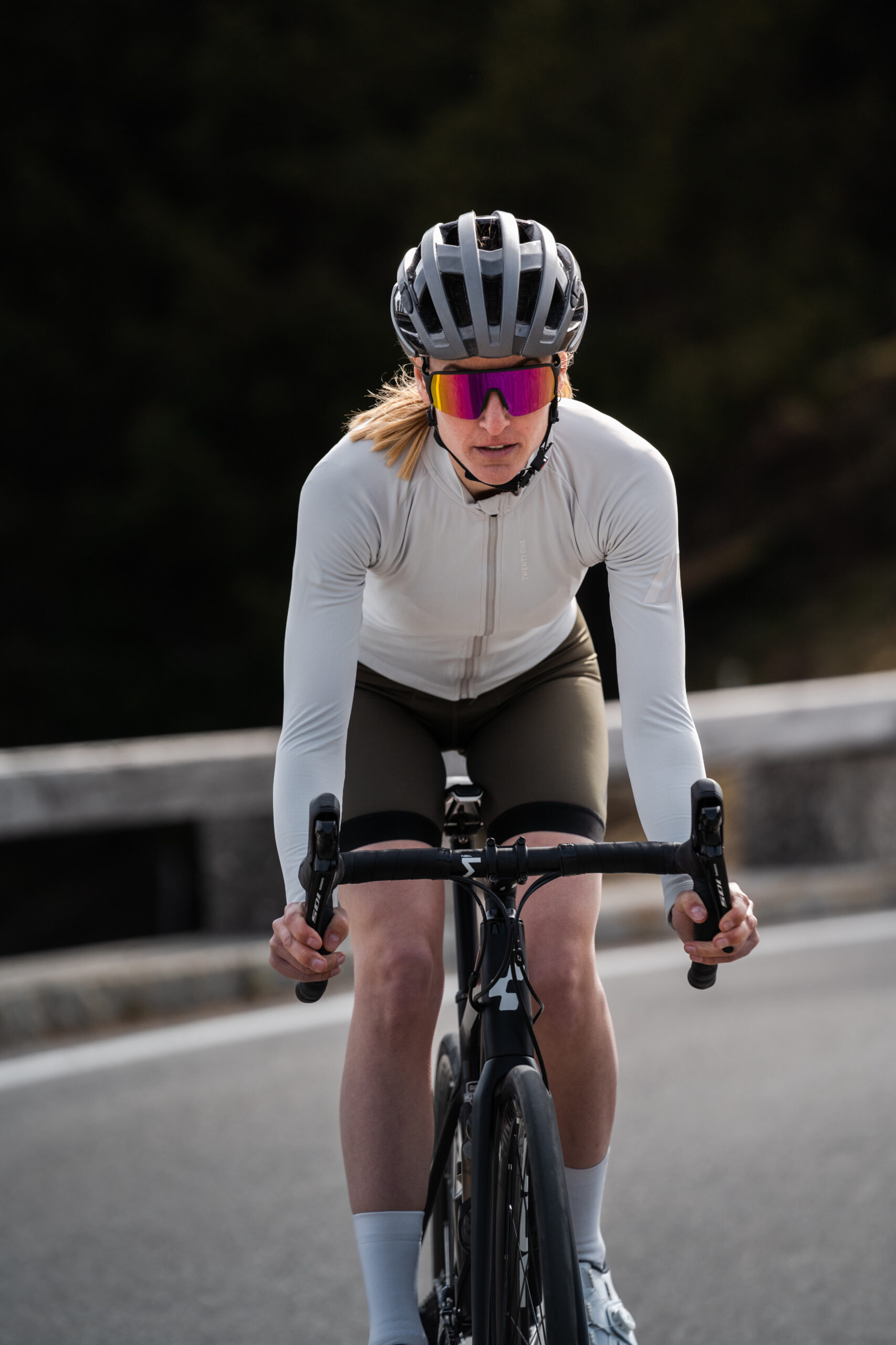 Women cyclist is riding a bicycle with the helmet and sports sunglasses