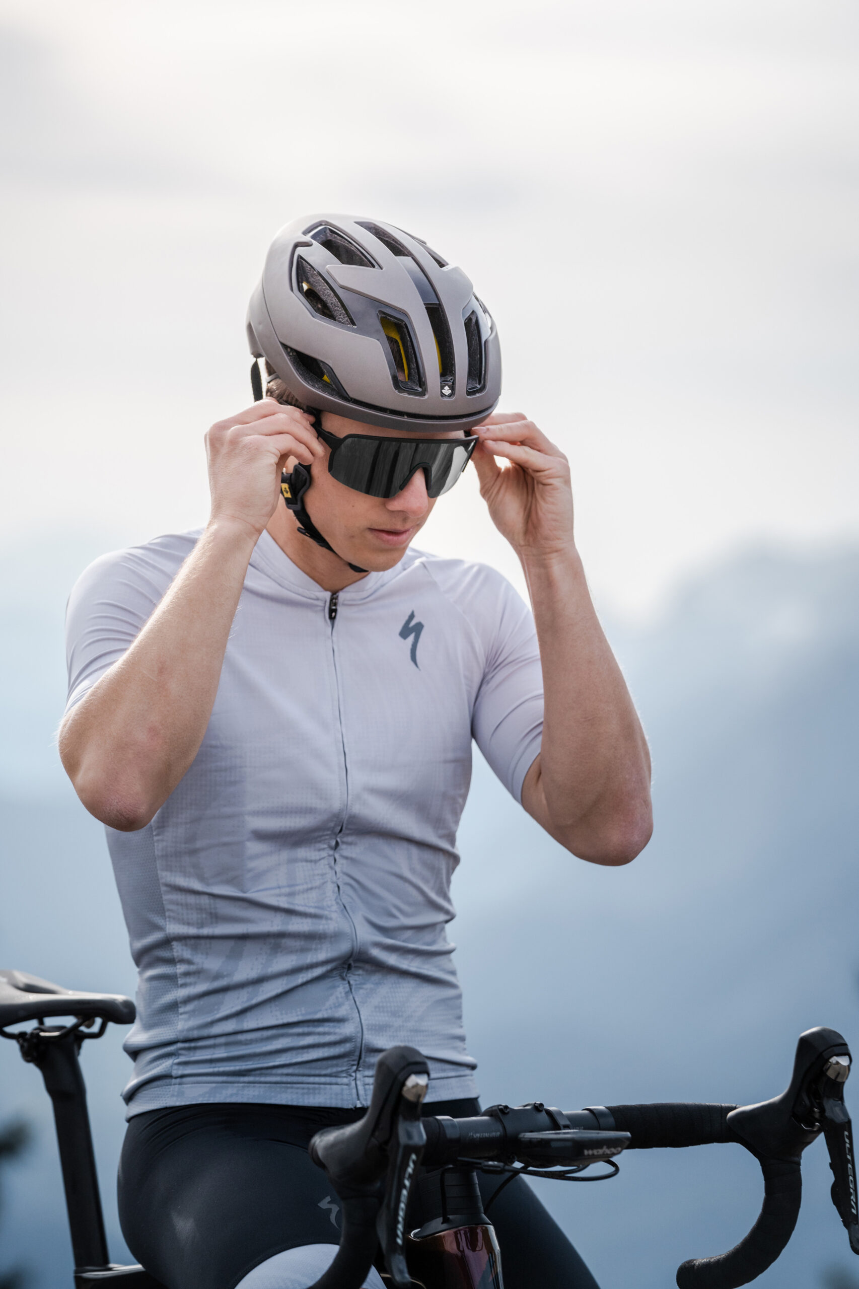 Cyclist is trying sports sunglasse on.