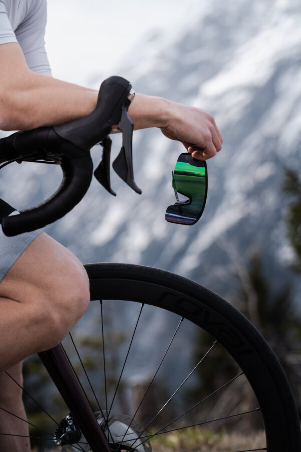 Cyclist is holding the sports sunglasses in hand